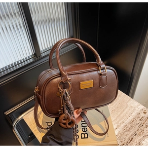 Detail der dunkelbraunen Vintage Boston Tasche mit goldenen Beschlägen und Ledertextur