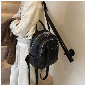 Detail des schwarzen Lederrucksacks mit silbernen Reißverschlüssen und Textur-Finish