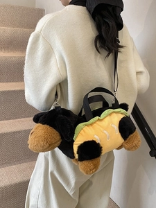 Cute plush dachshund hot dog crossbody bag with adjustable strap worn by model