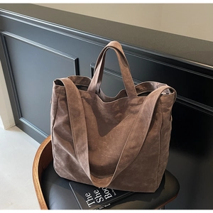 Brown large capacity suede tote bag displayed on a stylish chair in a modern room