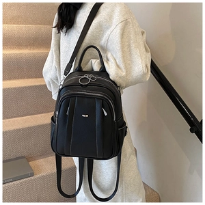 Nahaufnahme des schwarzen Rucksacks aus genarbtem Leder mit silbernen Ringreißverschlüssen