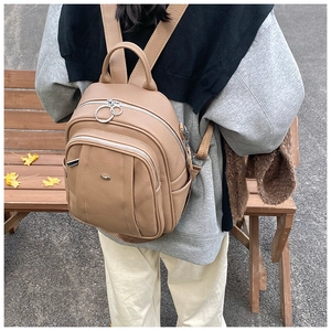 Nahaufnahme khakifarbener Lederrucksack mit Metallic-Ring-Reißverschluss im Street-Style-Look
