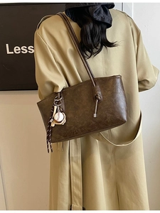 Retro brown large capacity tote bag with sports charm worn over the shoulder