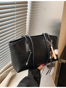 Retro black pleated tote bag with baseball charm and stylish knot shoulder strap detail