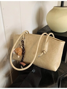 Chic beige textured faux leather tote bag with unique baseball glove pendant charm
