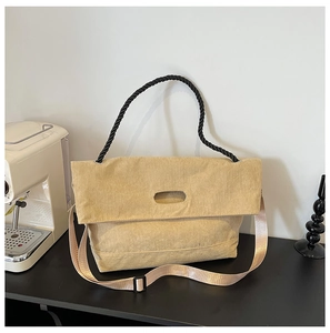 Detailed texture of khaki corduroy tote bag with woven rope handle and wide strap