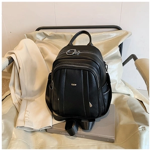 Detail eines schwarzen Lederrucksacks mit Kieselmaserung und Silber-Reißverschlüssen