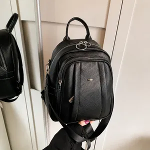 Detailansicht der schwarzen Lederstruktur und des silbernen Reißverschlusses am Rucksack