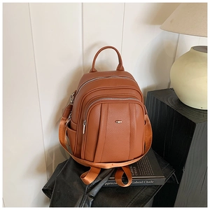 Detail eines braunen Lederrucksacks mit Litschi-Maserung und silbernen Reißverschlüssen
