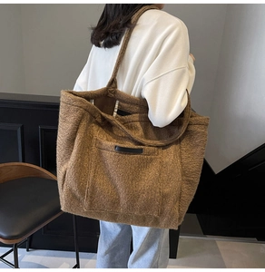 Detailed view of dark brown plush tote bag with black leather trim on a model