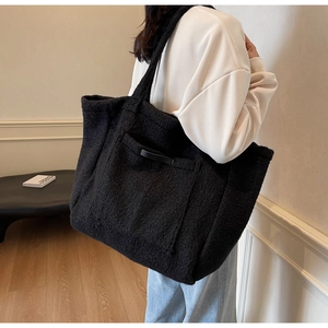 Detail of a black fuzzy tote bag showing plush texture and spacious shoulder carry design