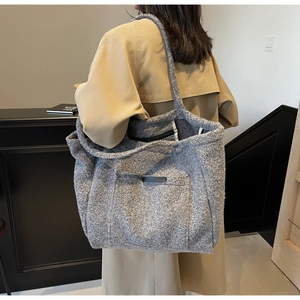 Close-up of a vintage grey plush tote bag with visible wool texture and slim shoulder strap
