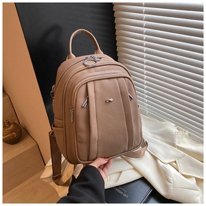 Detailaufnahme des khakifarbenen Lederrucksacks mit Metallring-Reißverschluss und Griff