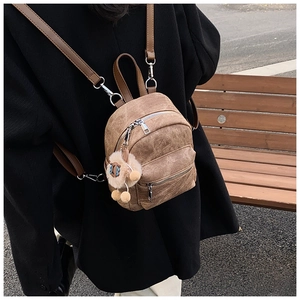 Detail van bruine vintage mini-rugzak met pluche lammetje en zilveren ritssluitingen