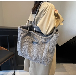 Close-up of a grey plush tote bag showing premium wool-like texture and interior pocket