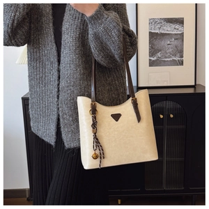Détail du sac cabas beige avec similicuir texturé et accessoire de bandoulière marron