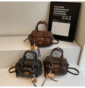Gros plan de sacs Boston vintage noirs et marron avec pendentifs de gant de baseball