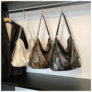Detailed view of large hobo tote bags in cream, brown, and grey with retro texture