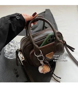 Sac bandoulière Boston marron foncé montrant une poche zippée pour grand smartphone