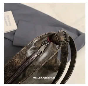 Close-up of high-quality dark grey metal zipper on brown vintage leather bag texture