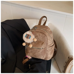 Detail van vintage bruine mini-rugzak met een schattige pluchen lammetje-hanger eraan
