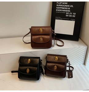 Close-up of vintage leather crossbody bags with dual flaps and gold metallic twist locks
