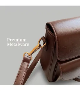 Detail shot of the leather shoulder bag side with golden metal buckle and fine stitching