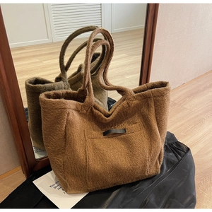 Detailed view of the brown plush tote bag showing soft texture and black leather pocket