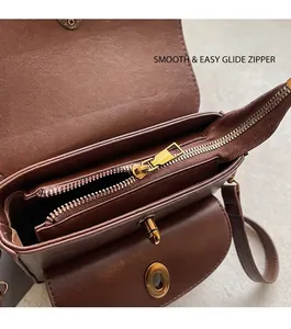 Detail view of smooth metal zipper and brown leather interior of the crossbody bag
