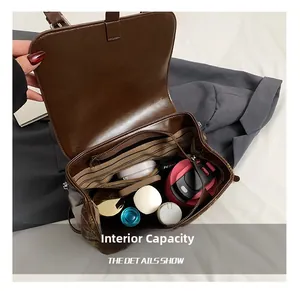 Capacità interna dello zaino in pelle marrone con fodera a righe e tasche multiple