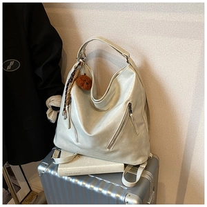 Detail of silver metallic tote bag with bear charm on a suitcase for office or travel