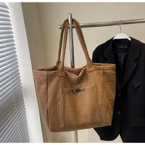 Detailed plush texture of brown tote bag hanging on a minimalist rack
