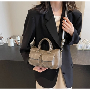 Detail view of retro grey-brown faux leather pillow bag with double front flap pockets