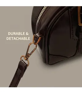 Detail of durable golden metal detachable buckle and shiny dark brown leather strap