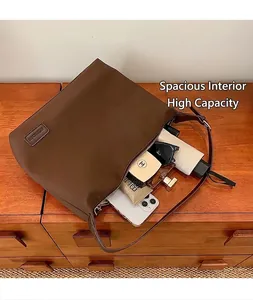 Vue de dessus du sac cabas spacieux en cuir marron avec fermeture éclair et accessoires