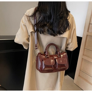 Deep burgundy patent leather bag featured on a trench coat for a chic vintage aesthetic