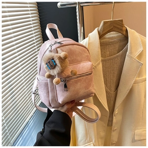 Detailopname van roze mini-rugzak met pluchen schaap-hanger bij modieuze kleding