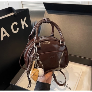 Nahaufnahme der glänzenden dunkelbraunen Bowling-Tasche aus Lackleder mit Baseball-Nähten