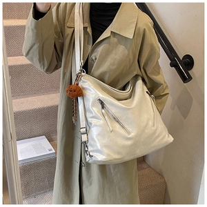 Detail showing pearlized PU leather tote bag texture with silver zipper and bear charm