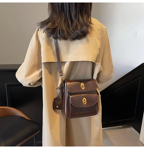 Detail showing the dark brown vintage leather crossbody bag with antique gold twist locks