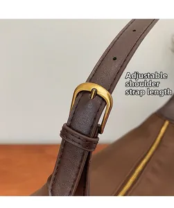 Gros plan sur la bandoulière en cuir réglable avec boucle en métal doré vieilli du sac