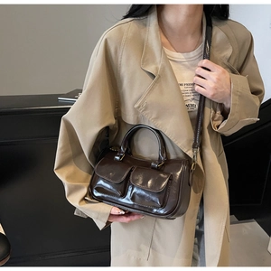 Close-up of retro brown patent leather bag with double pockets and mirror gloss finish