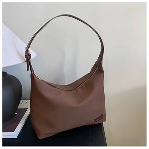 Détail du sac hobo marron montrant la texture en nylon et la boucle métallique réglable