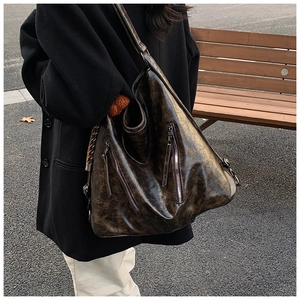 Outdoor shot of vintage distressed leather tote bag with stylish vertical dual zippers