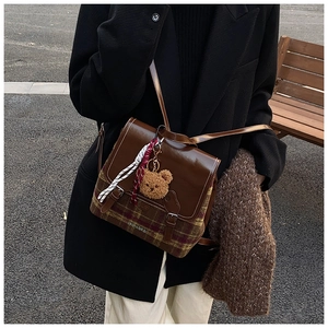 Dettaglio di uno zaino vintage stile inglese con tessuto scozzese e patta in pelle marrone