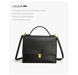 Detail of black pebbled leather crossbody bag with elegant gold hardware and top handle