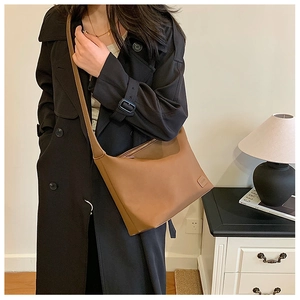 Détail d'un sac hobo marron montrant l'étiquette de marque sur le cuir synthétique mat
