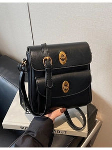 Classic black faux leather crossbody bag with dual golden twist locks and adjustable strap