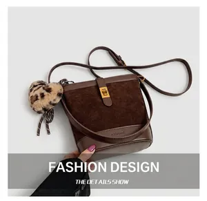 Detail of retro dark brown bucket bag featuring gold clasp and leopard print heart charm