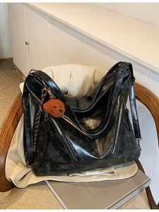Vintage black distressed tote bag with zipper details and a brown plush bear charm